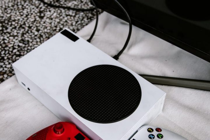 xbox console and wireless controllers on a white cloth